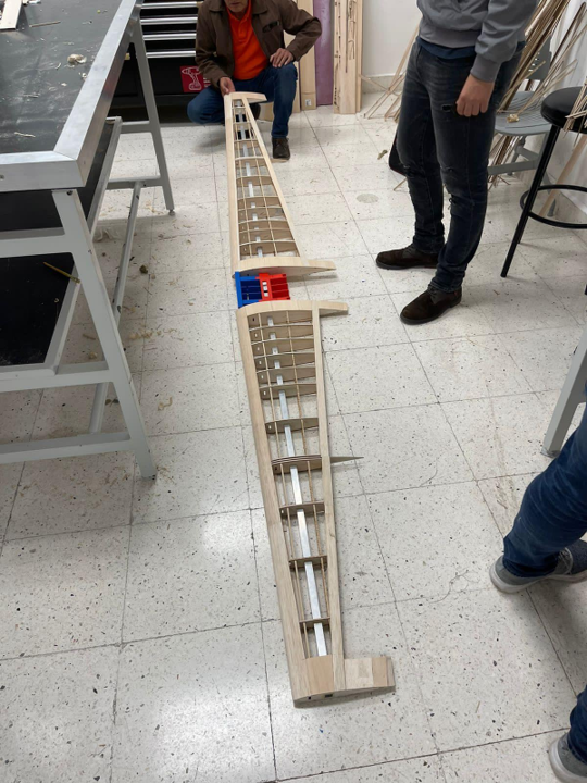 Long wooden aircraft wing structure during shop assembly