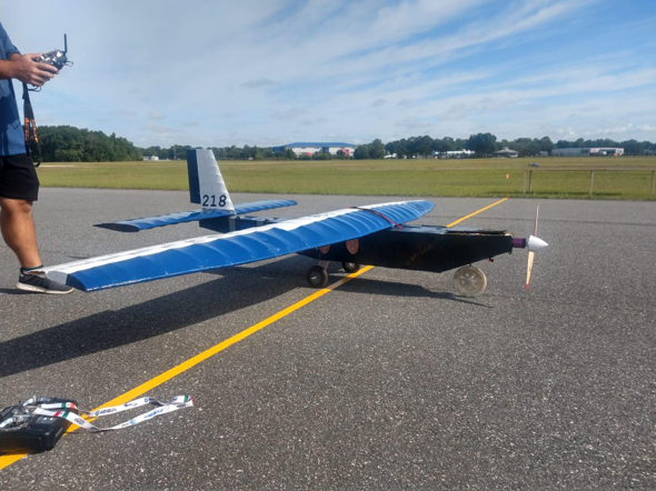 Blue and black competition aircraft on an airfield runway